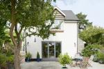 Evolution Storm Windows in cream complimentd with a three part bi fold door leading into the garden